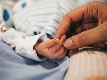 mother holding a baby hand